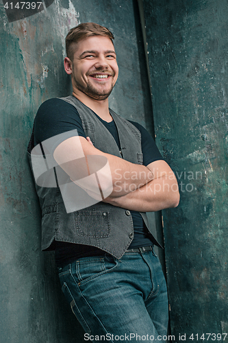 Image of Portrait of smiling happy man standing in studio