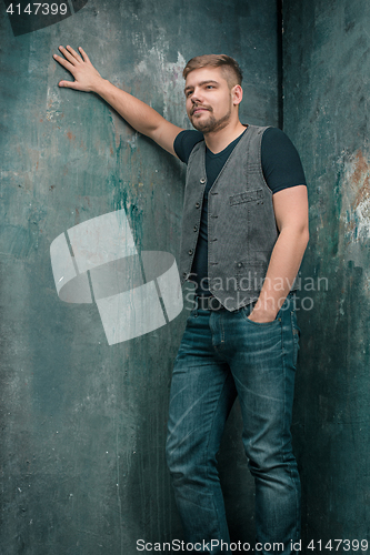 Image of Portrait of smiling happy man standing in studio