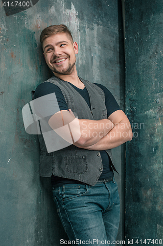 Image of Portrait of smiling happy man standing in studio