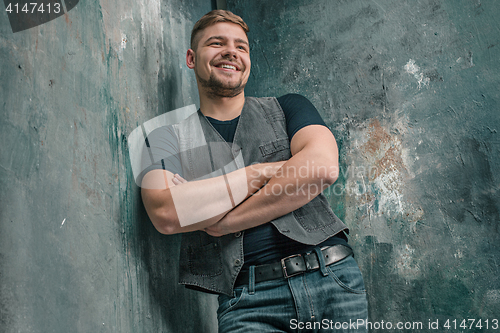 Image of Portrait of smiling happy man standing in studio