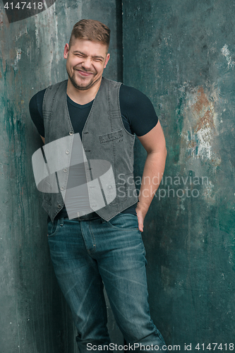 Image of Portrait of smiling happy man standing in studio