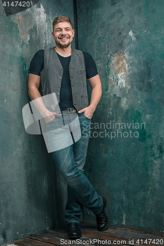 Image of Portrait of smiling happy man standing in studio