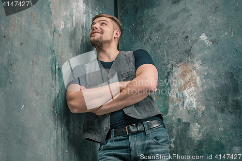 Image of Portrait of smiling happy man standing in studio