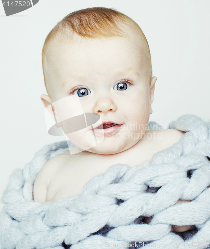 Image of little cute red head baby in scarf all over him close up isolate