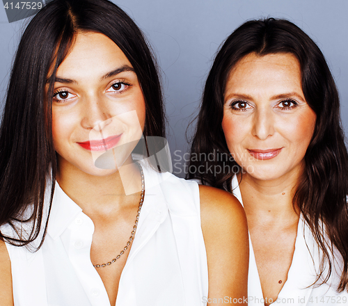 Image of cute pretty teen daughter with mature mother hugging, fashion st