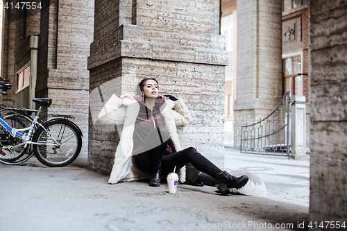 Image of young pretty stylish teenage girl outside on city street fancy f