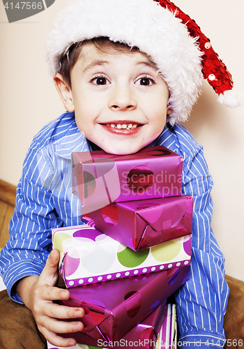 Image of little cute boy with Christmas gifts at home. close up emotional