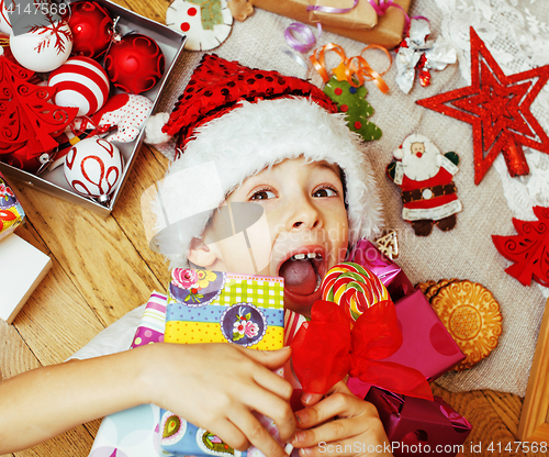 Image of little cute boy with Christmas gifts at home. close up emotional