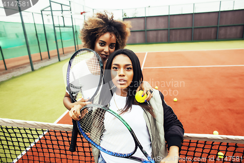 Image of young pretty girlfriends hanging on tennis court, fashion stylis