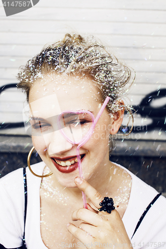 Image of young pretty party girl smiling covered with glitter tinsel, fas