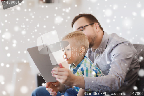 Image of father and son with tablet pc playing at home