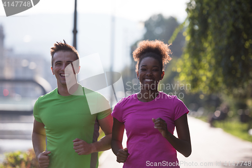 Image of young multiethnic couple jogging in the city
