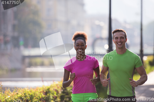 Image of young multiethnic couple jogging in the city