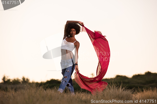 Image of black girl dances outdoors in a meadow