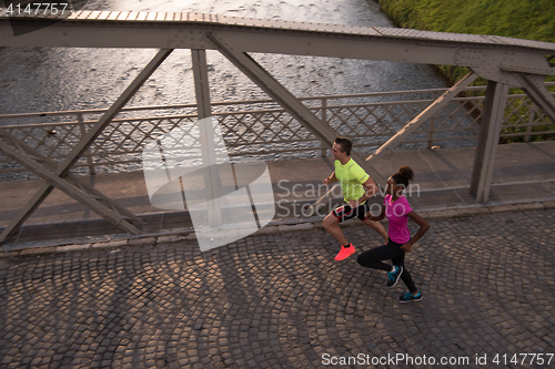 Image of young multiethnic couple jogging in the city