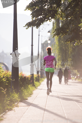 Image of african american woman jogging in the city