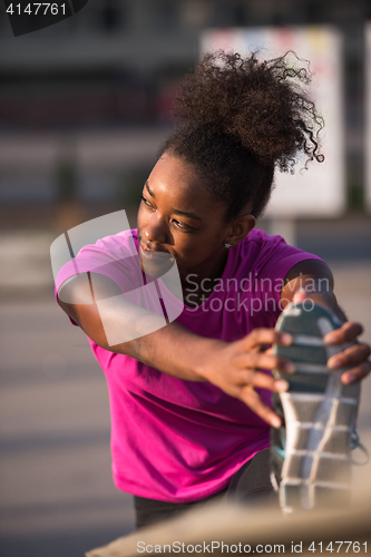 Image of African American woman doing warming up and stretching