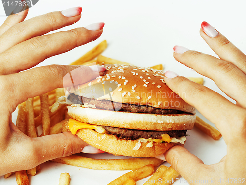 Image of woman hands with manicure holding hamburger and french fries iso