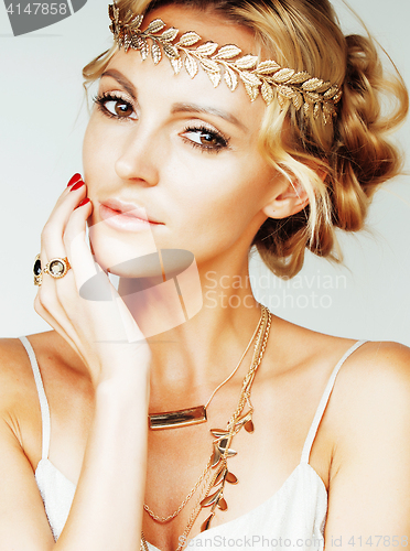 Image of young blond woman dressed like ancient greek godess, gold jewelr
