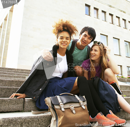 Image of cute group of teenages at the building of university with books 