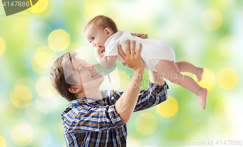 Image of happy young father playing with baby over lights