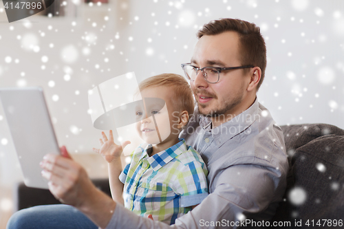 Image of father and son with tablet pc playing at home