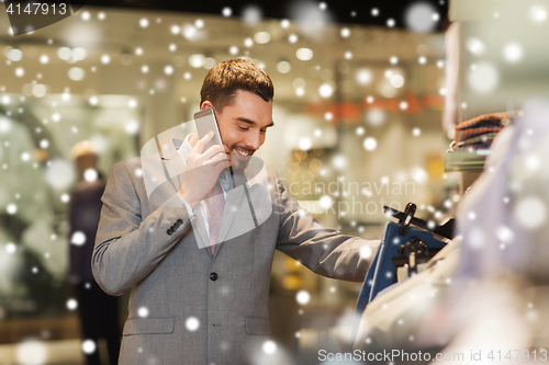 Image of happy man calling on smartphone at clothing store