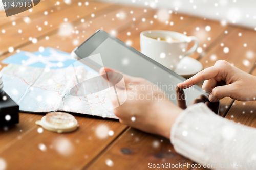 Image of close up of traveler hands with tablet pc and map