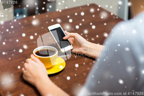 Image of woman with smartphone drinking coffee at cafe