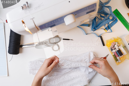 Image of Dressmaker working with white cloth