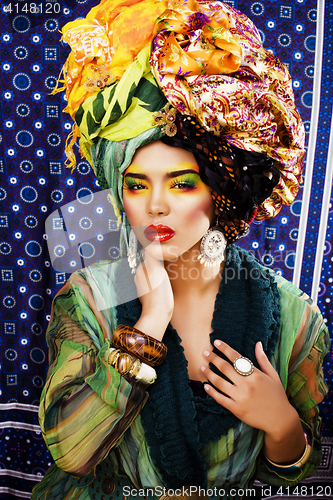 Image of beauty bright woman with creative make up, many shawls on head l