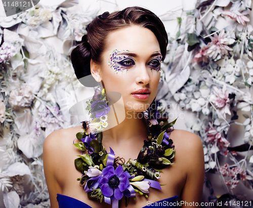 Image of floral face art with anemone in jewelry, sensual young brunette 