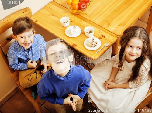 Image of little cute boys eating dessert on wooden kitchen. home interior. smiling adorable friendship together forever friends, lifestyle people concept