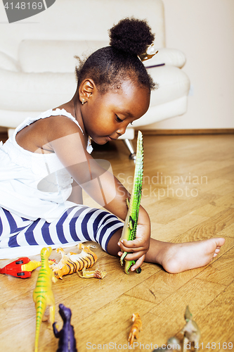 Image of little cute african american girl playing with animal toys at ho