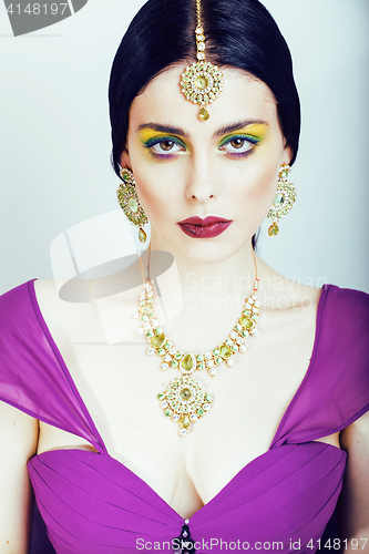 Image of young pretty caucasian woman like indian in ethnic jewelry close up on white, bridal makeup