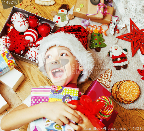 Image of little cute boy with Christmas gifts at home. close up emotional