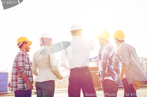 Image of group of builders and architects at building site