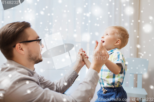 Image of father with son playing and having fun at home