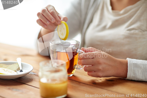 Image of close up of ill woman drinking tea with lemon