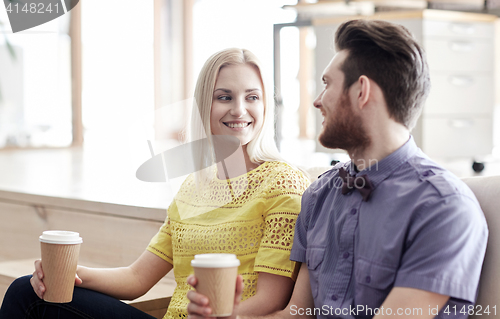 Image of happy man and woman drinking coffee in office