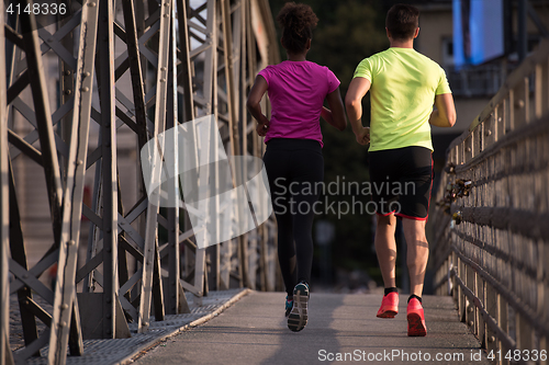 Image of multiethnic couple jogging in the city