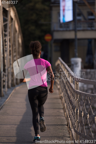 Image of african american woman running across the bridge