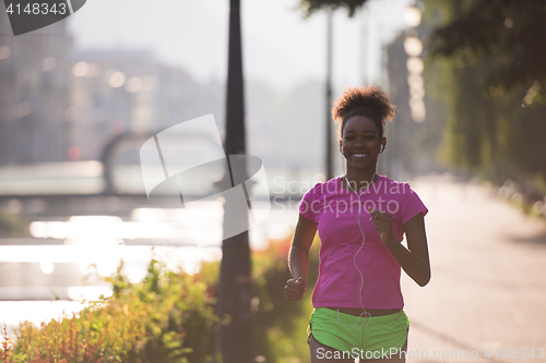 Image of african american woman jogging in the city