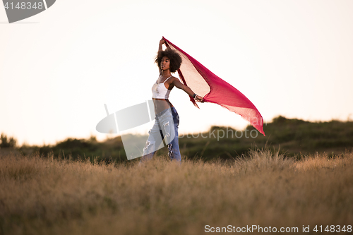 Image of black girl dances outdoors in a meadow