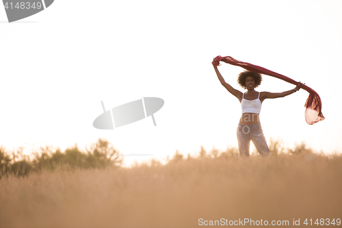 Image of black girl dances outdoors in a meadow