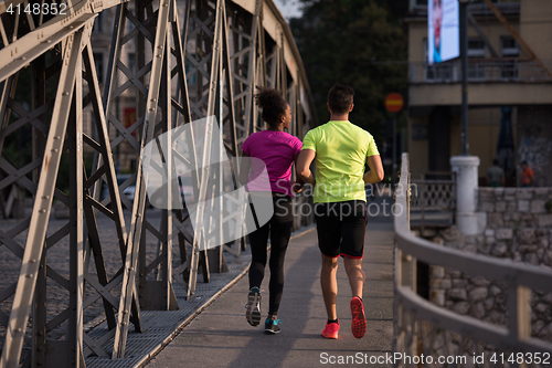 Image of multiethnic couple jogging in the city
