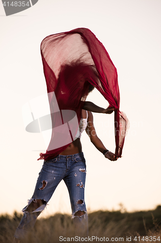 Image of black girl dances outdoors in a meadow