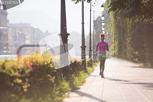 Image of african american woman jogging in the city