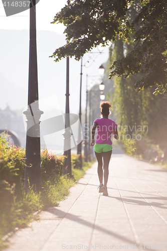 Image of african american woman jogging in the city