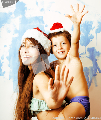 Image of funny family in red hats celebrating new year, mother with son happy smiling, lifestyle people concept